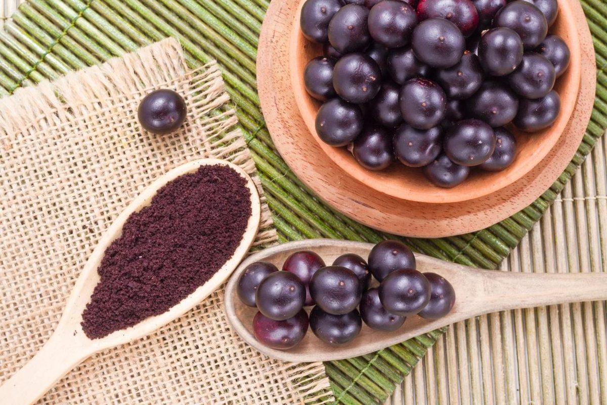 Frutos de açaí e polpa em colher de madeira